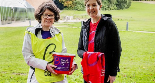 Two people outside at a bucket-collection for Blood Cancer UK.