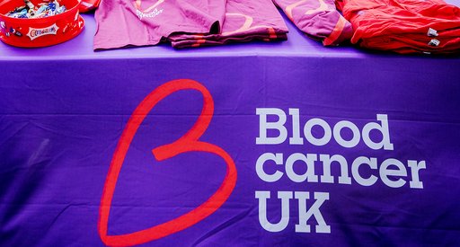 Two people outside at a bucket-collection for Blood Cancer UK.