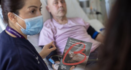Nurse giving a patient a blood cancer uk flyer