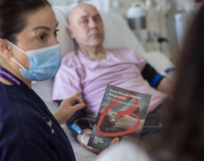 Nurse giving a patient a blood cancer uk flyer