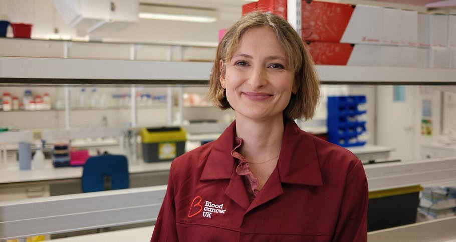 Charlotte Graham, researcher at Kings College London, smiling in her Blood Cancer UK lab coat.