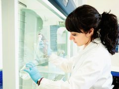 Dr Rasha Rezk working in the lab, wearing a white lab coat.