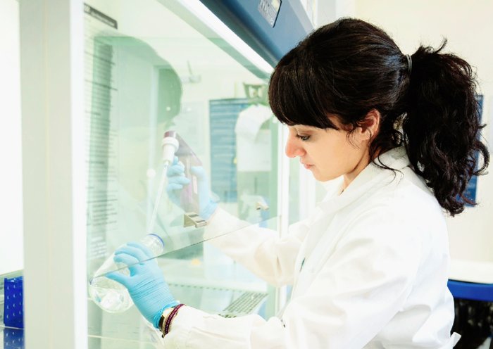 Dr Rasha Rezk working in the lab, wearing a white lab coat.