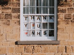 View from outside a window displaying the words 'Thank you NHS' with a heart emoji and a smiley face with heart eyes.