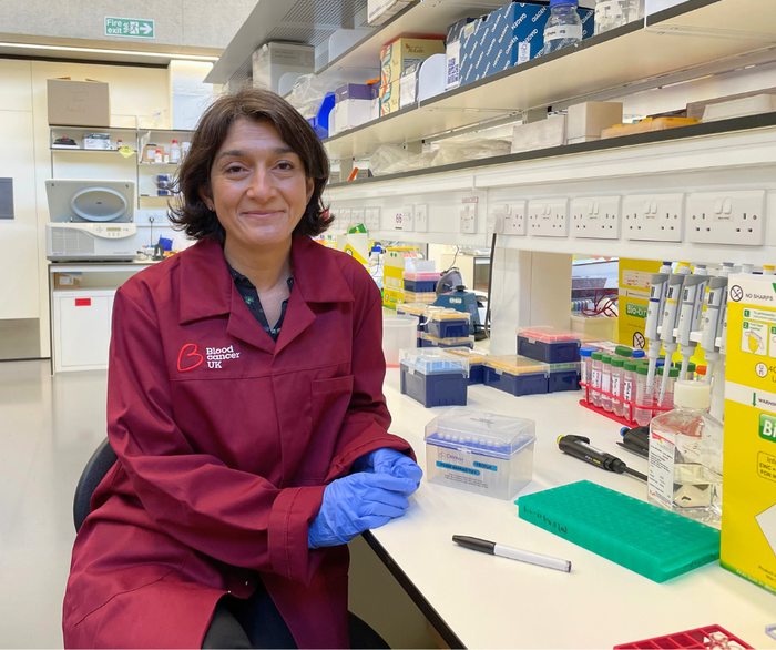 Dr Sara Ghorashain stood in the lab smiling wearing a Blood Cancer UK lab coat.