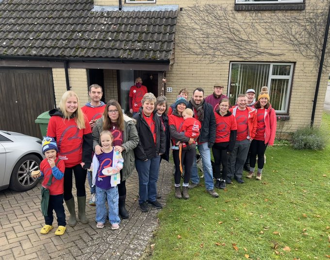 A group of people wearing red Blood Cancer UK branded t-shirts, outside, ready to take on a walk to raise money to beat blood cancer.