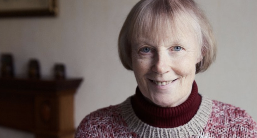 A headshot of Erica, who has chronic lymphocytic leukaemia (CLL), wearing a thick knitted jumper smiling into the camera.