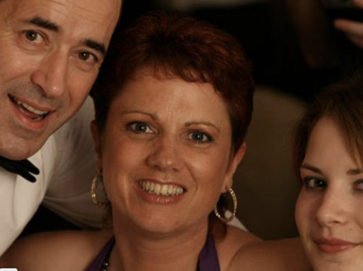 A close-up of Donna, who was diagnosed with follicular lymphoma, smiling with family at a formal event.