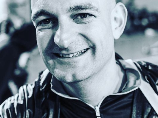 Headshot of Blood Cancer UK trustee Steven Prescott-Jones in a black and white image smiling at the camera.