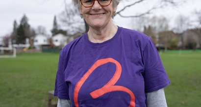 Female wearing purple Blood Cancer UK t-shirt smiling for the camera