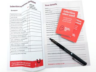 Infection alert card showing red front cover. Inside there is space to write your symptoms and personal details to share with medical staff.