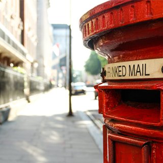 A red London postbox on a city street