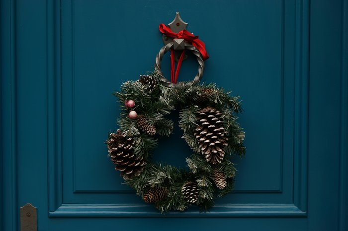 A green front door with a Christmas wreath