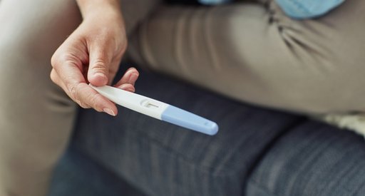 A hand holding a pregnancy test