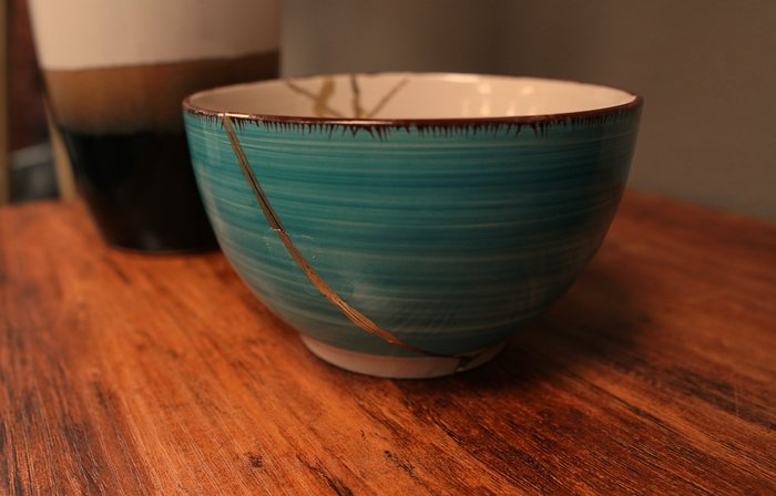 An example of the Japanese art of Kinsugi: a blue-green bowl repaired using gold lacquer.