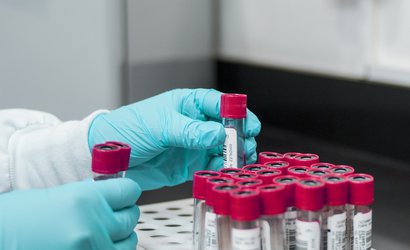 A researcher puts test tubes containing blood into a rack