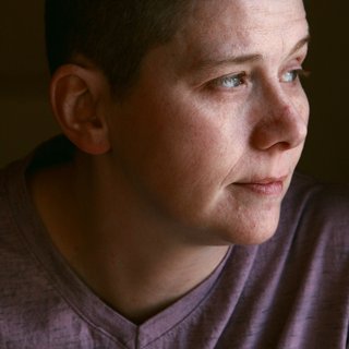 A person, alone, looking away with a thoughtful expression